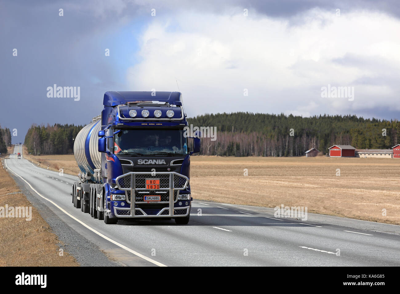 JOKIOINEN, FINLAND - APRIL 23, 2017: Dark blue Scania R580 tank truck with bull bar in ADR haul along straight road through rural landscape in South o Stock Photo