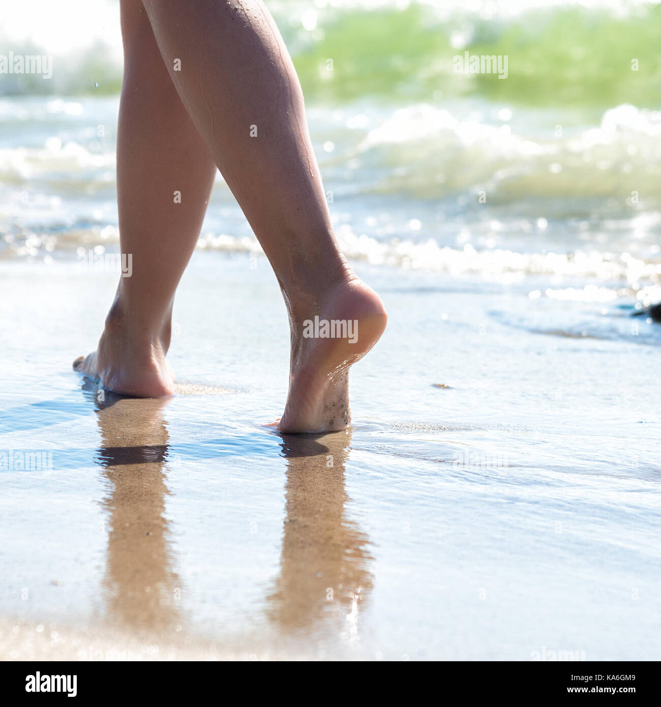 Woman walking on sand beach leaving footprints in the sand Stock Photo ...