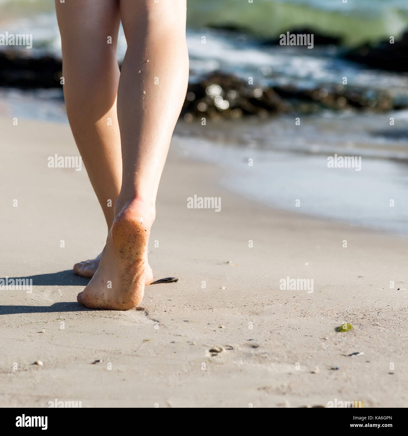 Woman walking on sand beach leaving footprints in the sand Stock Photo ...