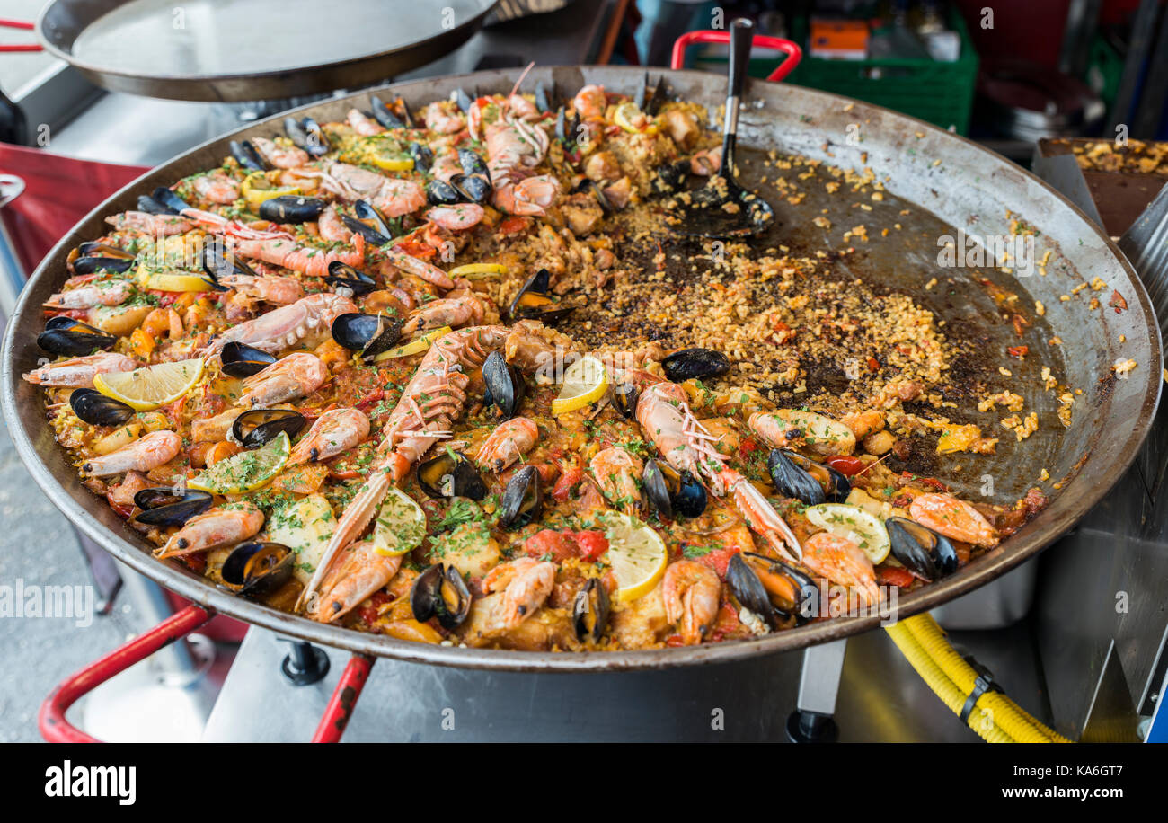 big pan with fish paella food on heating fire for tourists to buy and eat in Bergen Norway Stock Photo