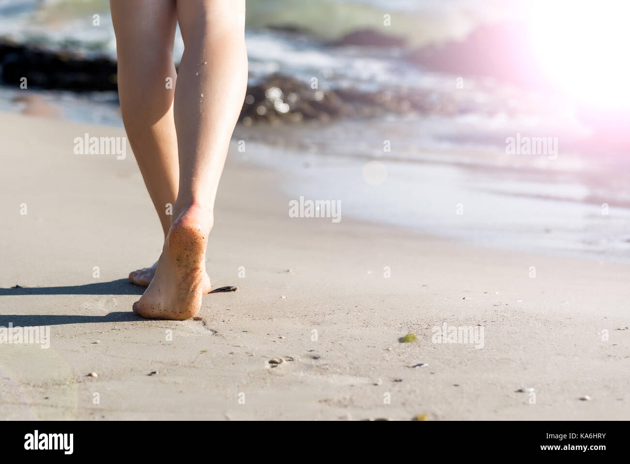 Woman walking on sand beach leaving footprints in the sand Stock Photo ...