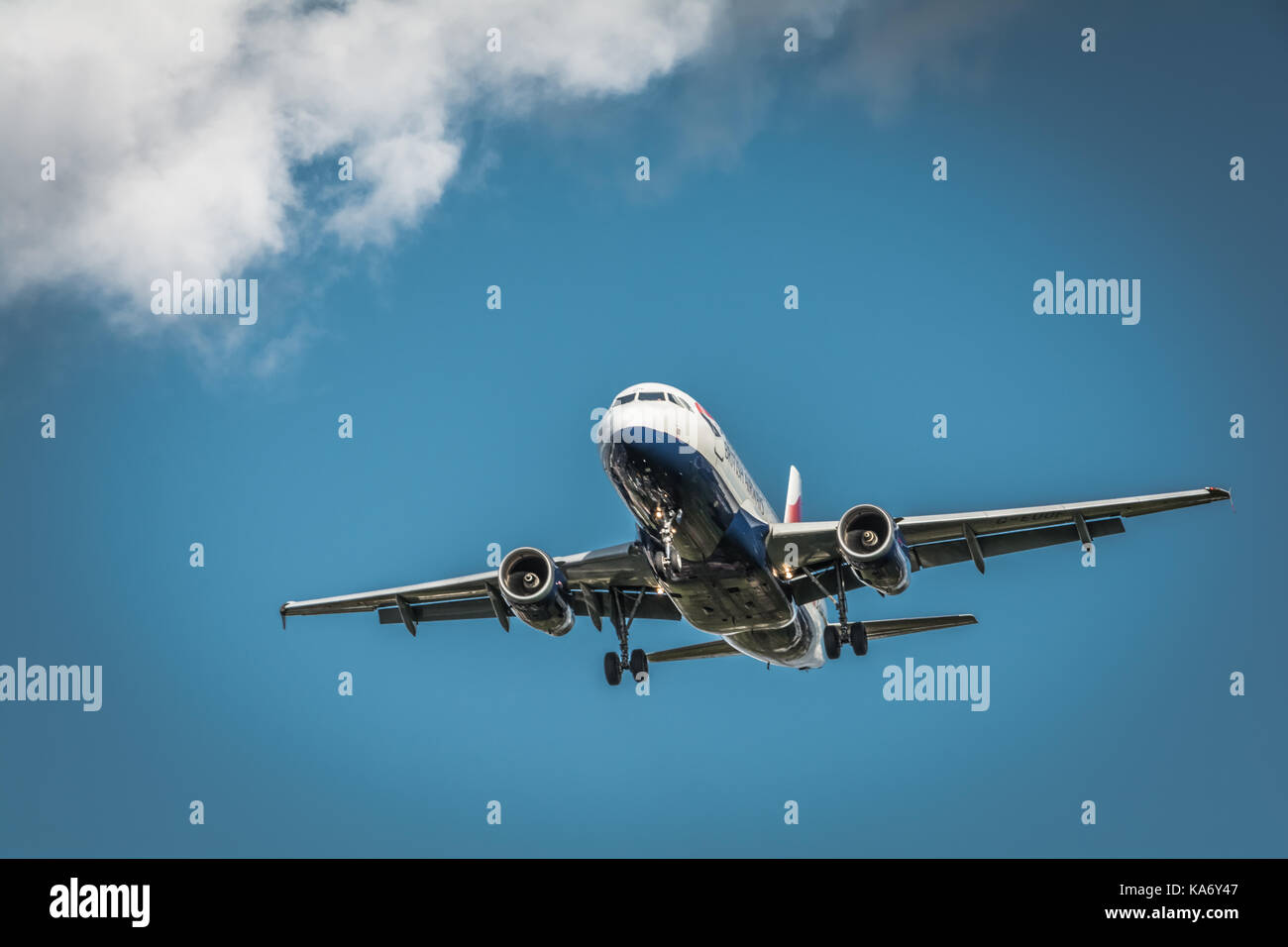 A low fow flying jet aircraft descending towards Heathrow Airport, Terminal 4, in Hounslow, Middlesex, UK. Stock Photo