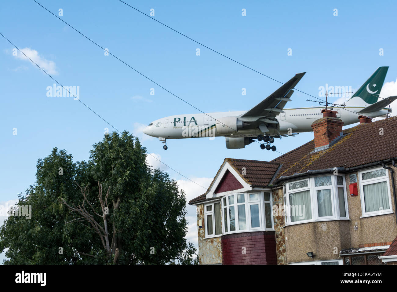 A low flying PIA plane coming in to land above Myrtle Avenue at Heathrow airport, London, UK Stock Photo