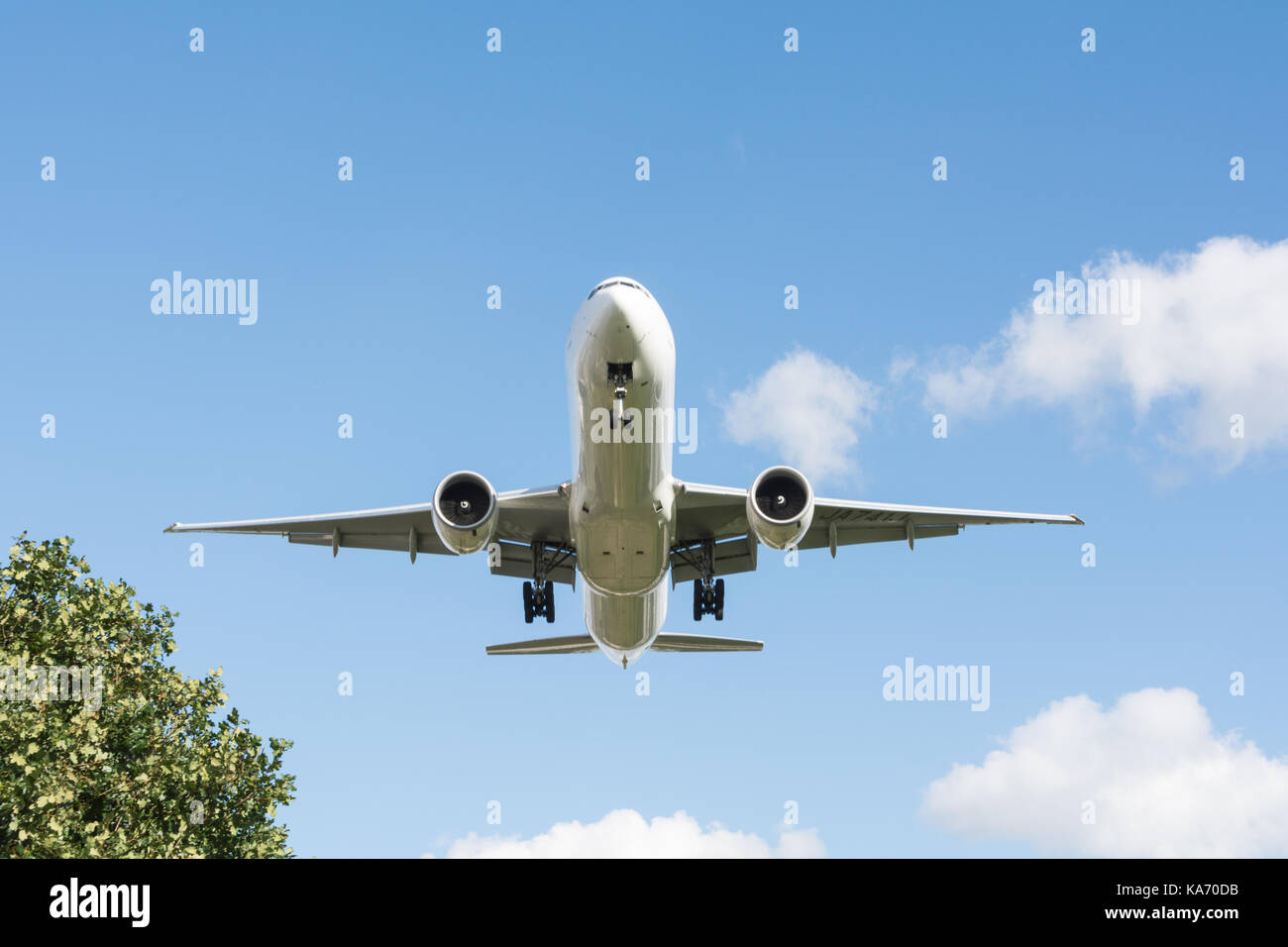 A low flying jet aircraft descending towards Heathrow Airport, Terminal 4, in Hounslow, Middlesex, UK. Stock Photo