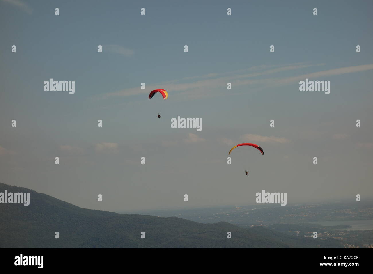 Adrenalin sport. Paragliding man in the blue sky of Laveno Mombello, Italy Stock Photo