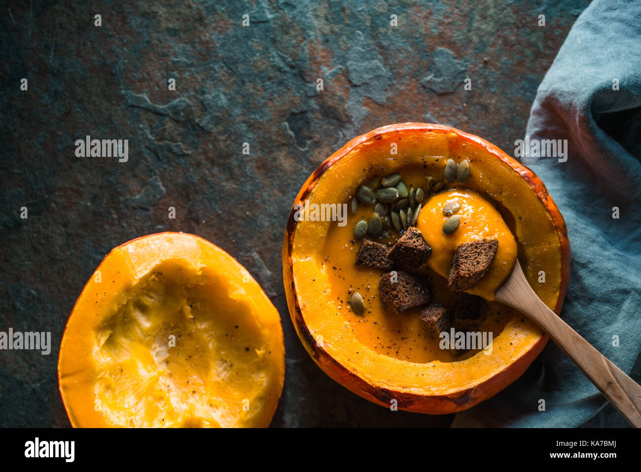 Spoon in pumpkin with soup, sunflower seeds and croutons horizontal Stock Photo
