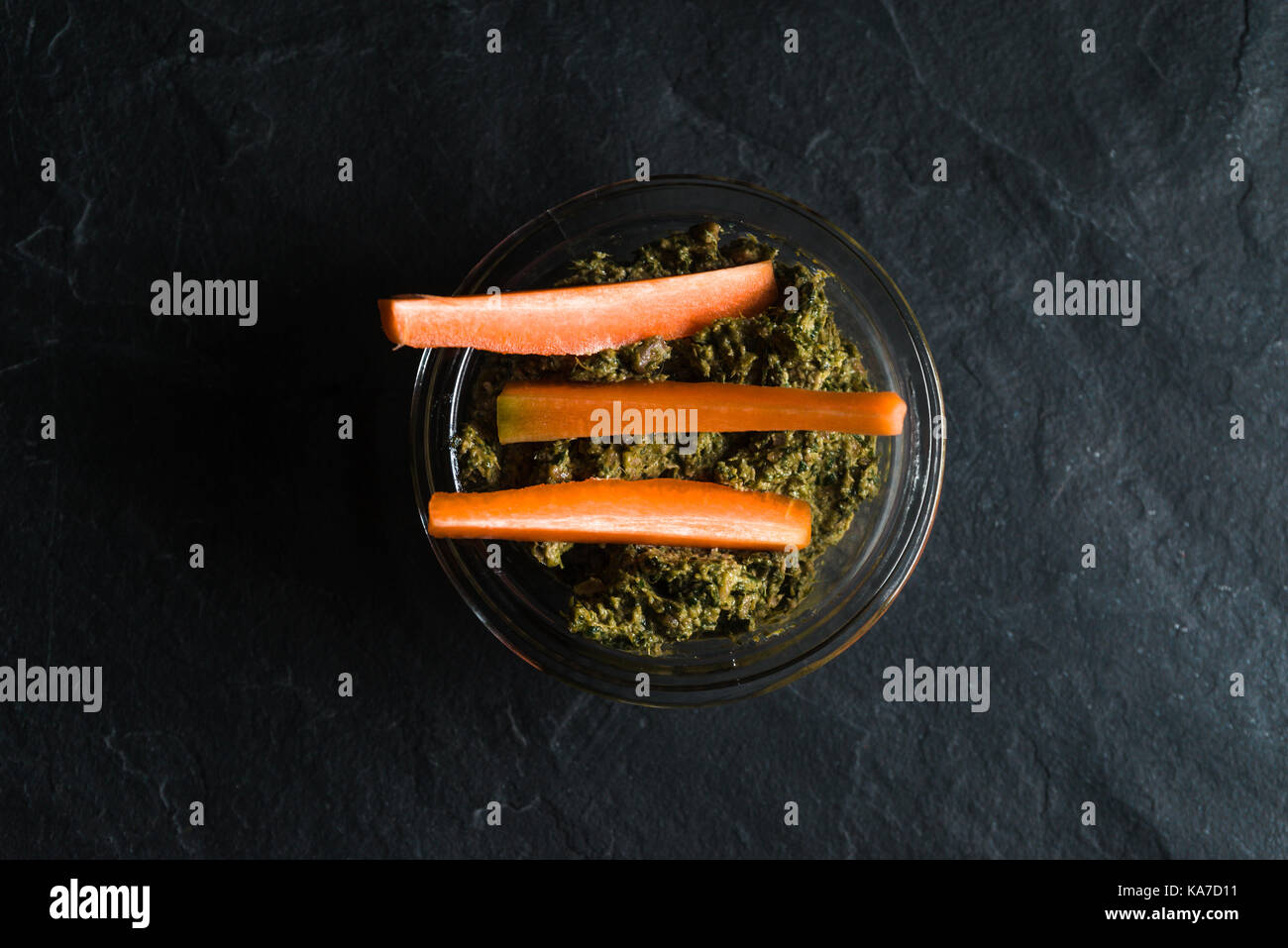 Pesto of carrot tops and carrots on a gray background horizontal Stock Photo