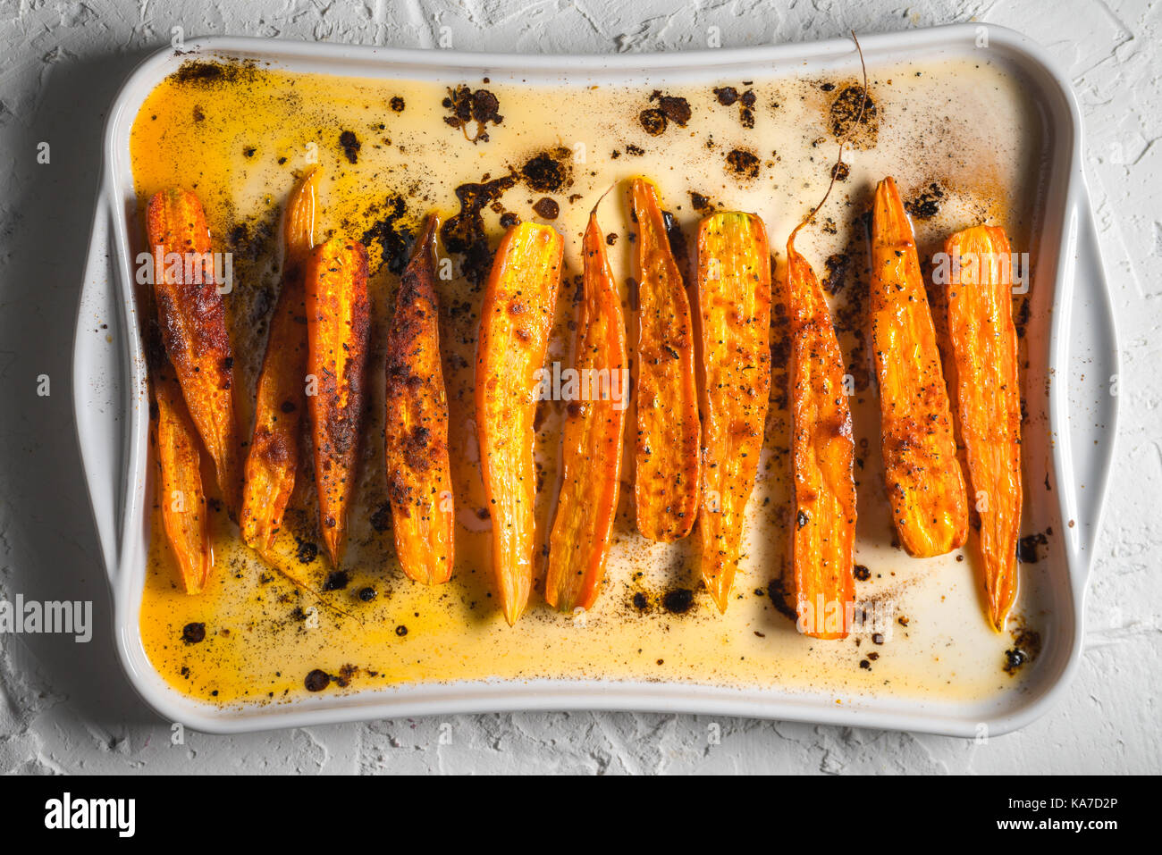 Stewed carrots in spices on a ceramic baking sheet top view horizontal Stock Photo