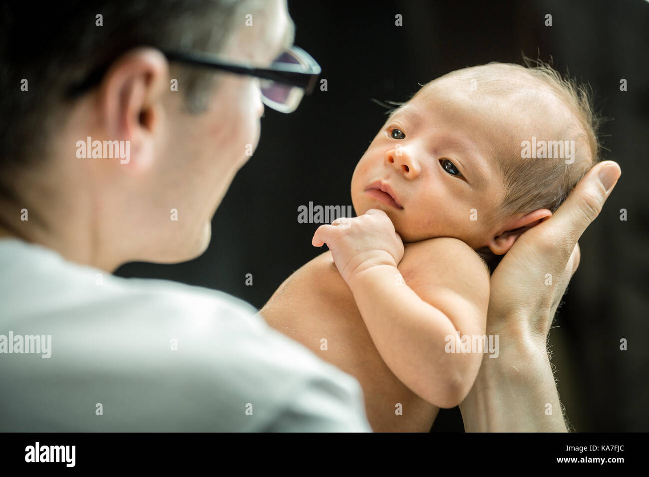 Happy father holding with love his 3 weeks old son Stock Photo