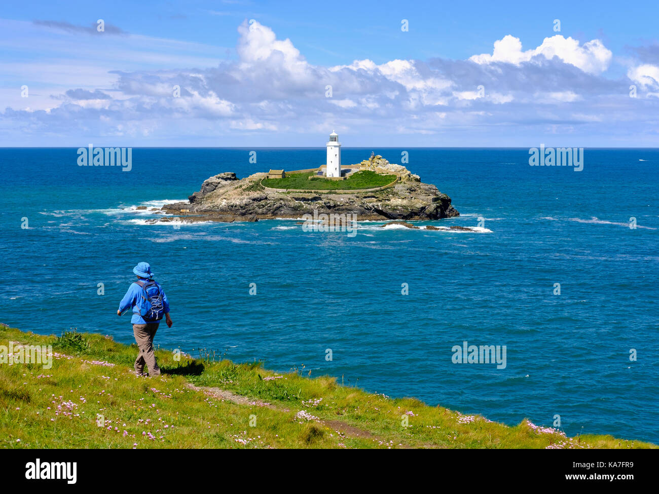 Woman hikes on coastal route at Godrevy Point, Godrevy Lighthouse on Godrevy Island, near Gwithian, Cornwall, England Stock Photo