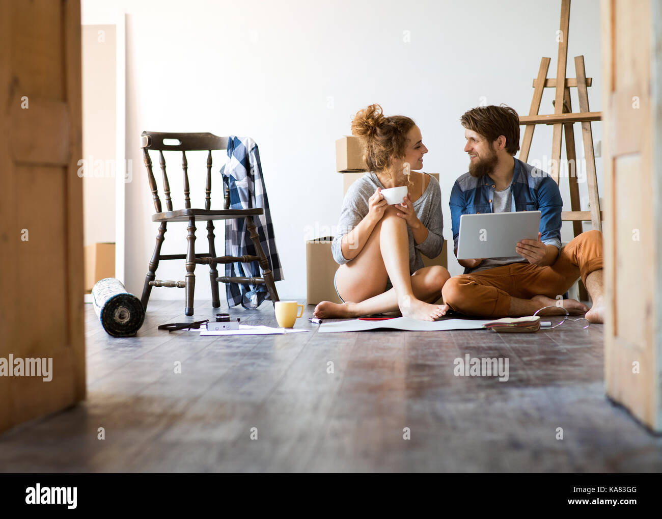 Young couple moving in new house, unpacking things. Stock Photo