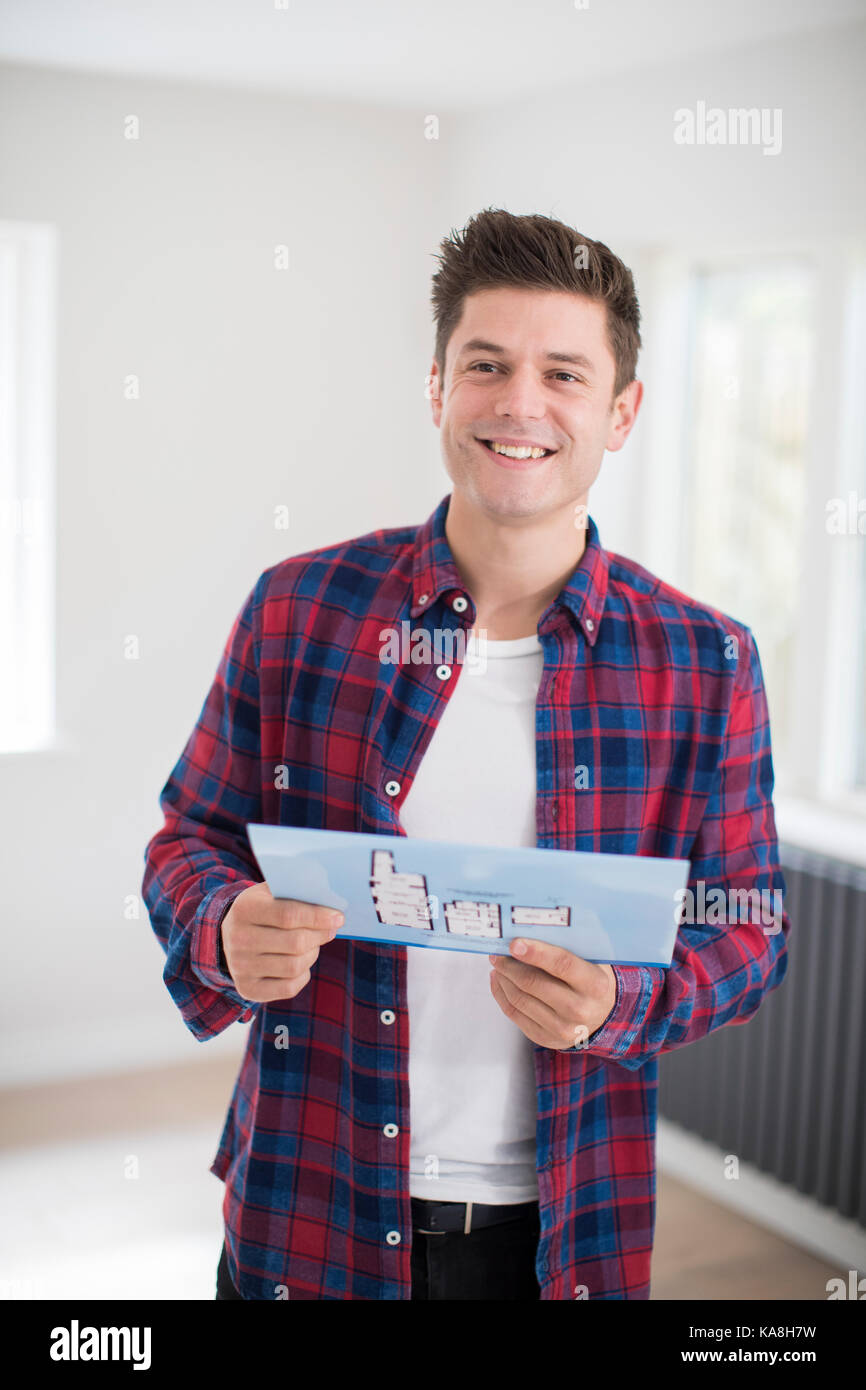 Man Looking At Brochure With Details For New Home Stock Photo
