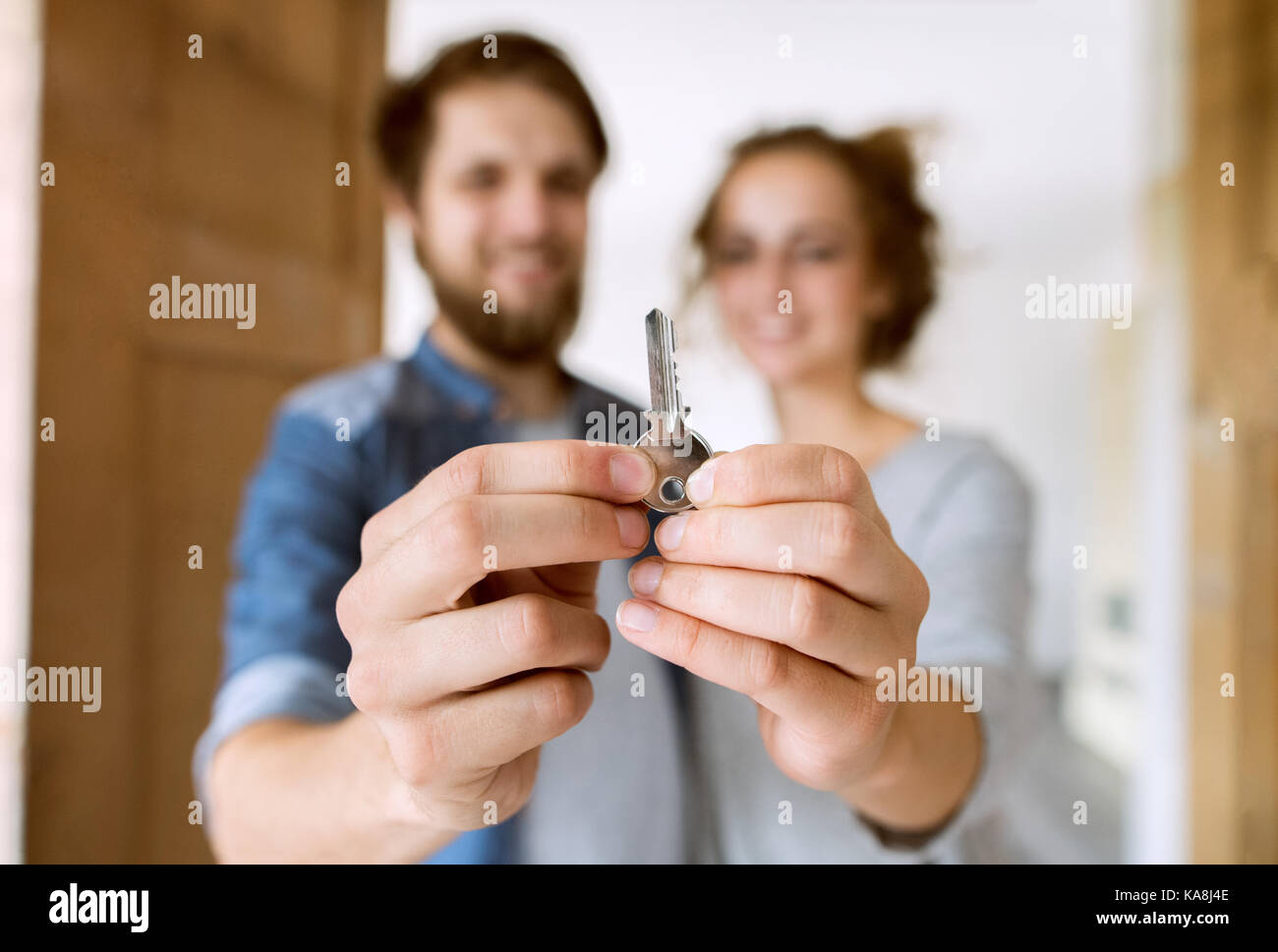 Couple with a key moving into their new house Stock Photo - Alamy