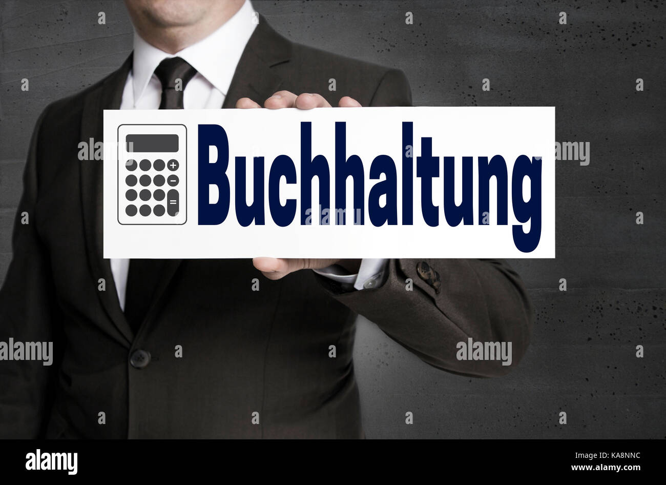Buchhaltung (in german Accounting) signboard is held by businessman. Stock Photo