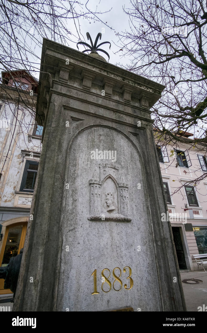 Stone fountain at Skofja loka Town square built in 1883 with the relief of Coat of Arms. Stock Photo