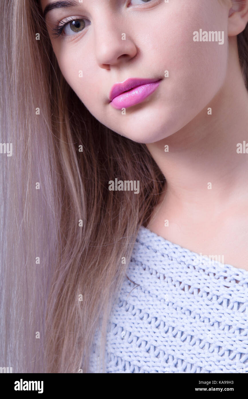 Close up shot of a beautiful woman with pink colored lipstick on her lips and multicolored hair Stock Photo