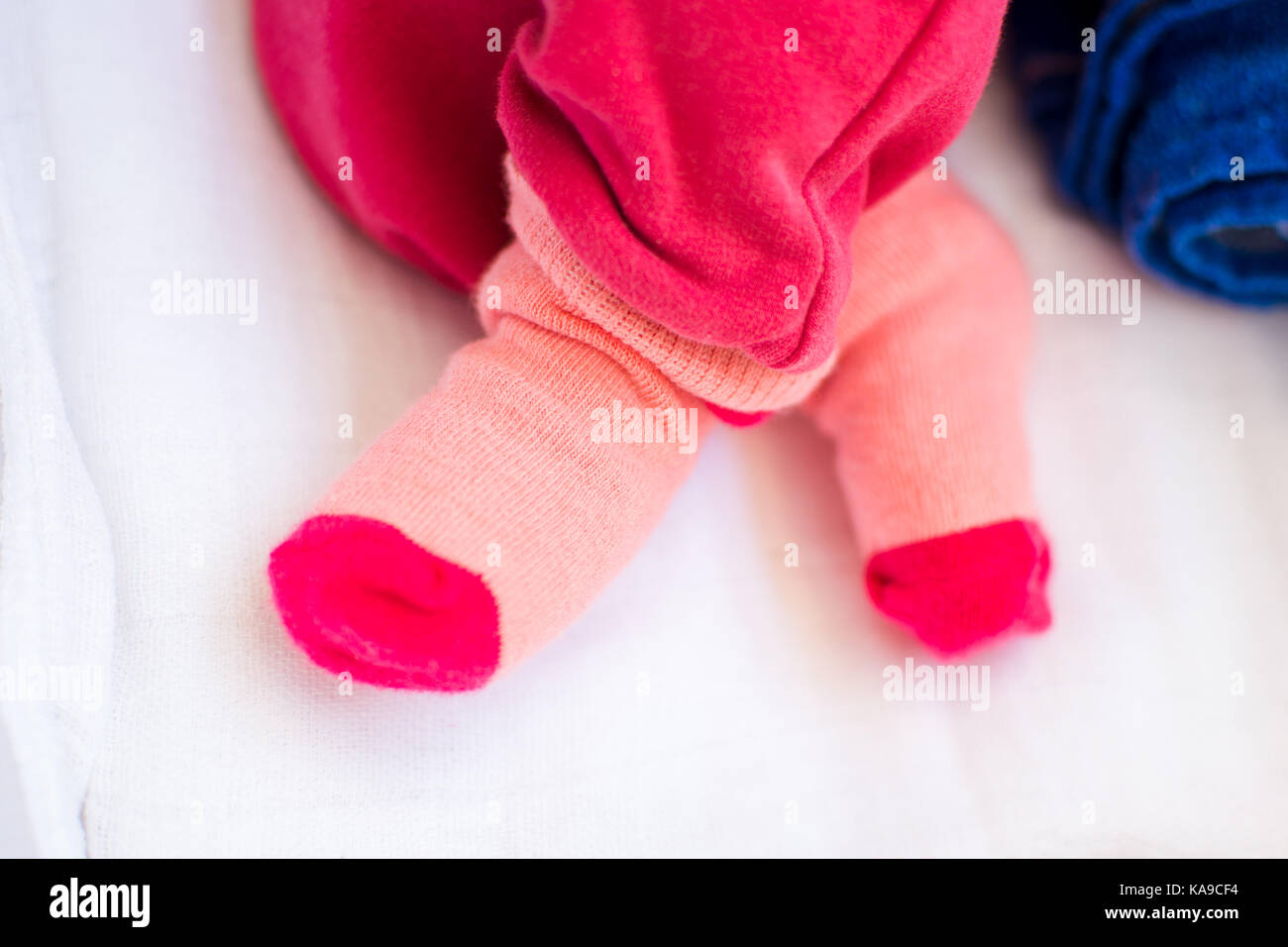 Baby girl feet wearing cute socks close up Stock Photo