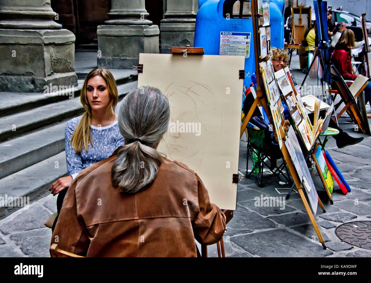 Street artist in Florence, Italy drawing a young woman at Uffizi Piazzale Stock Photo