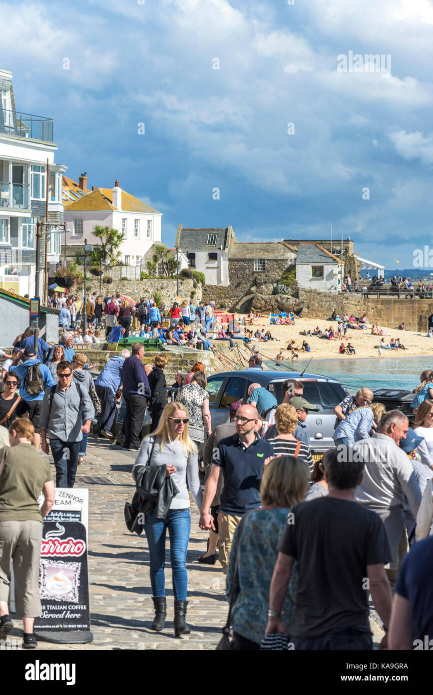 St Ives - holidaymakers relaxing and strolling around St Ives Harbour Beach in Cornwall. Stock Photo