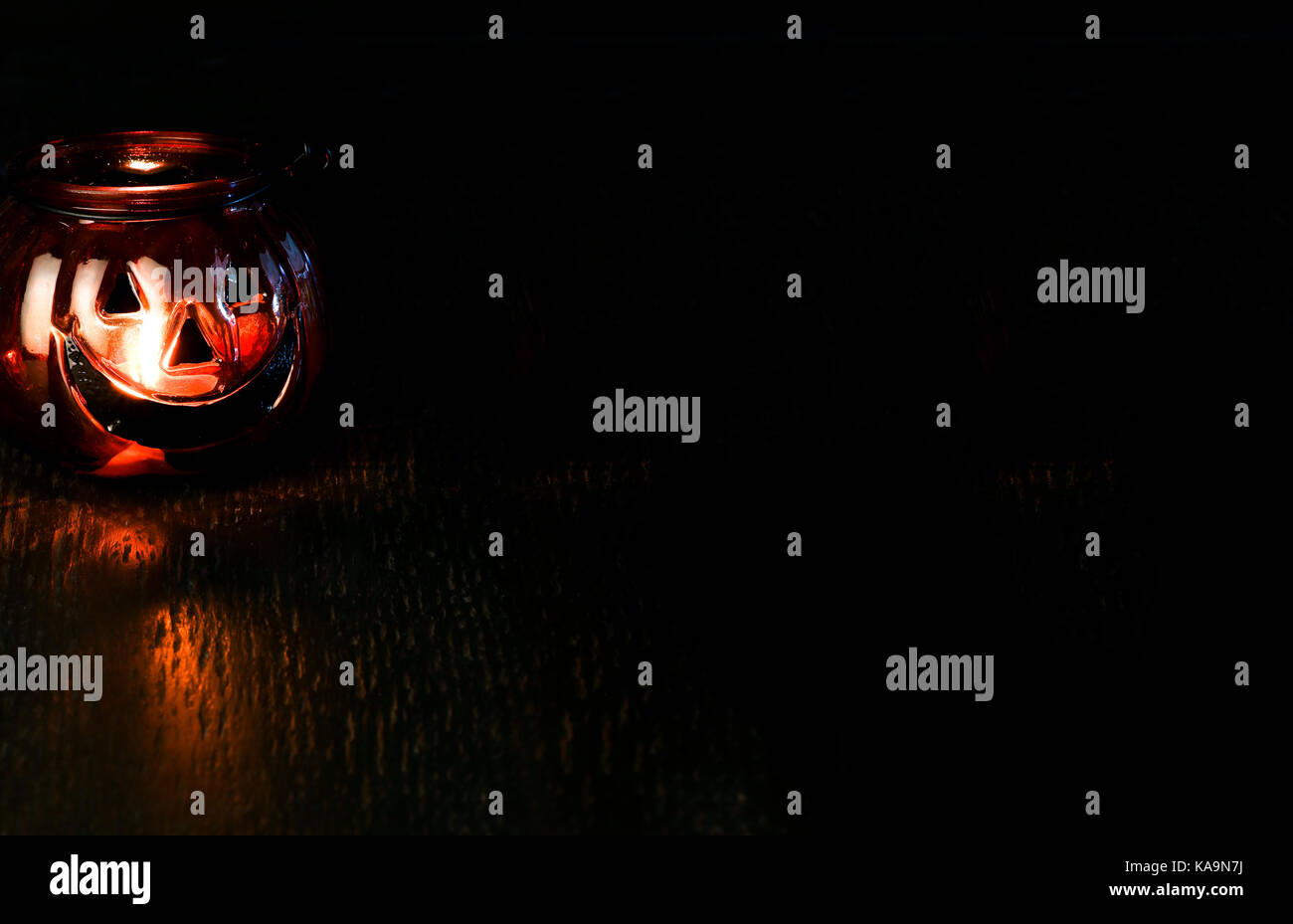 Halloween pumpkin head bowl lantern on dark background with copy space Stock Photo