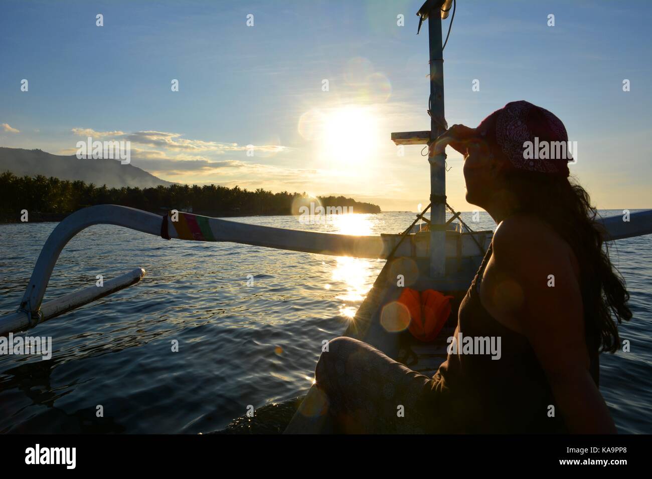 Woman on a traditional balinese boat enjoying the sunset Stock Photo