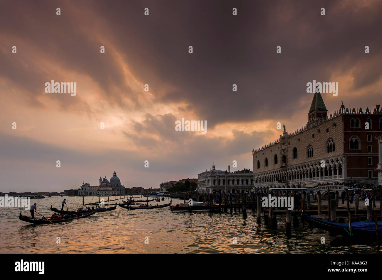 Sunset on Venice canals with Gondoliers steering their Gondolas Stock ...