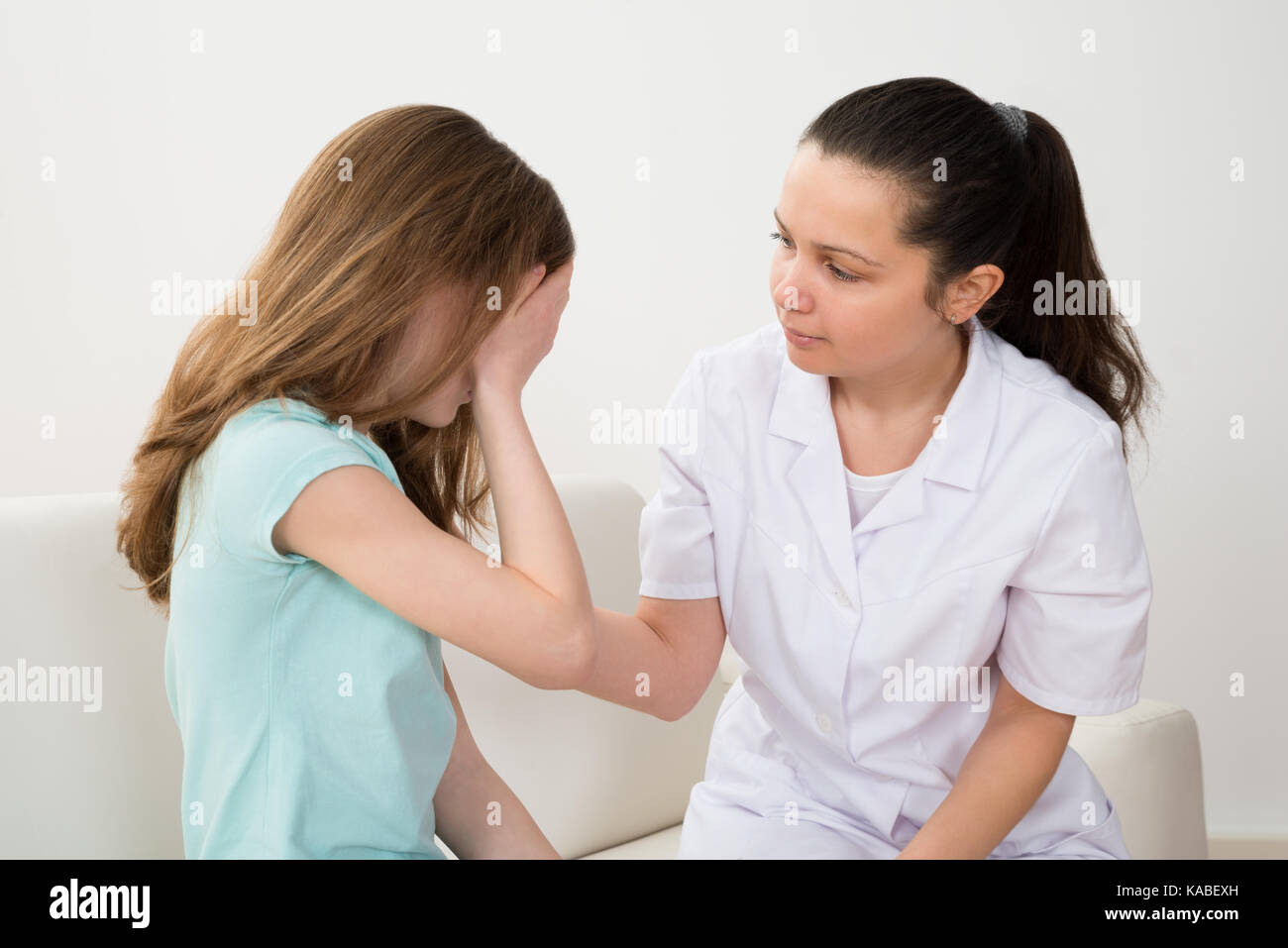 Female Doctor In Labcoat Comforting Patient Crying In Hospital Stock Photo