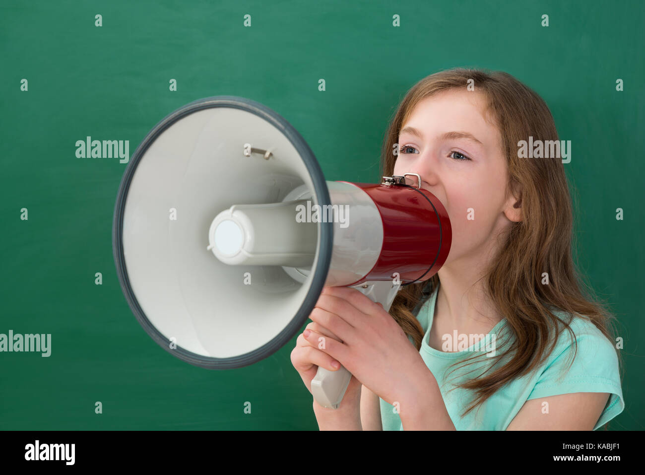 Girl Announcing On Megaphone Against Chalkboard In Classroom Stock ...