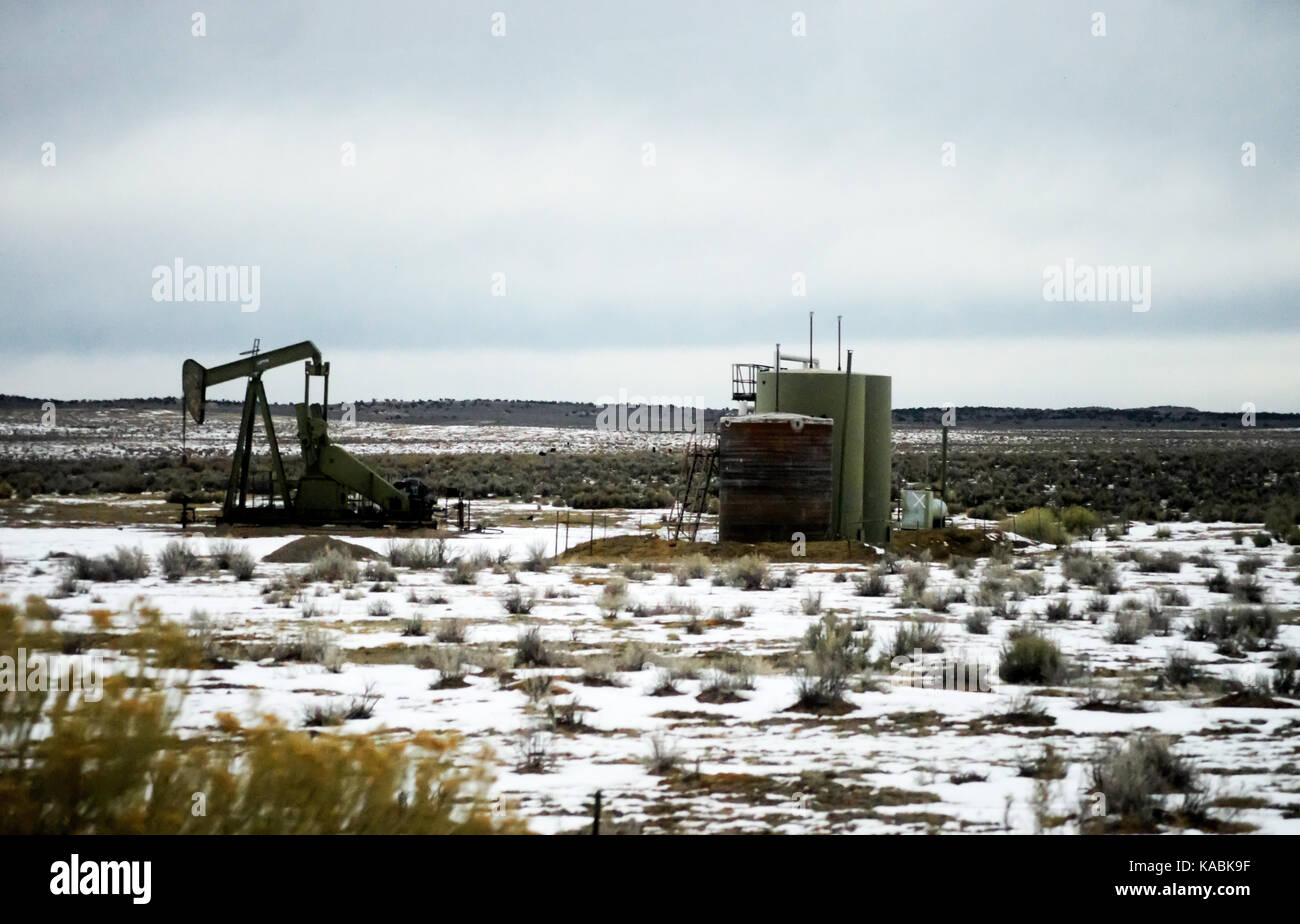 A old green oil rig pumping oil in a snow covered plain. Concept. Stock Photo