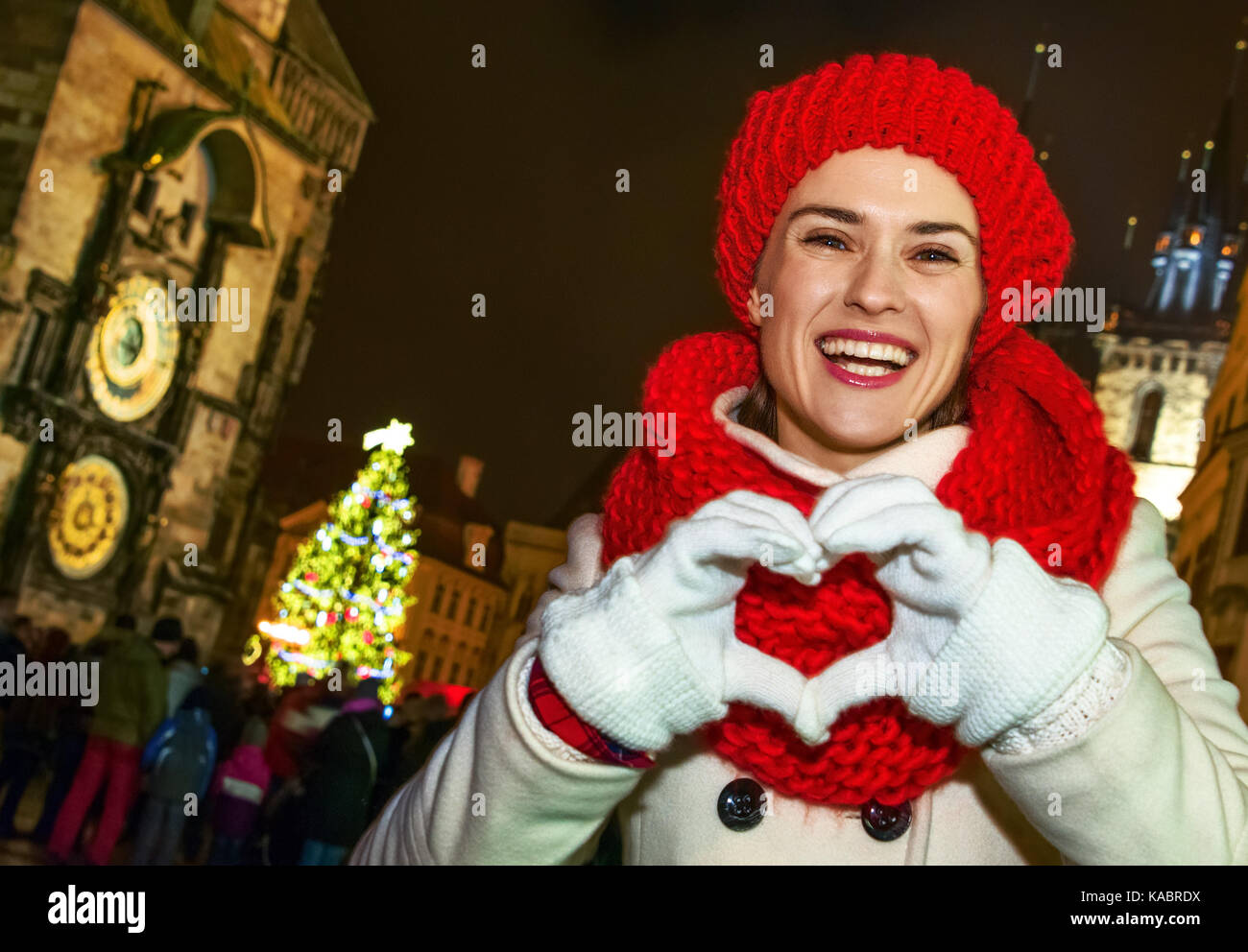 Magic on streets of the old town at Christmas. smiling young tourist woman in red hat and scarf at Christmas on Old Town Square in Prague Czech Republ Stock Photo