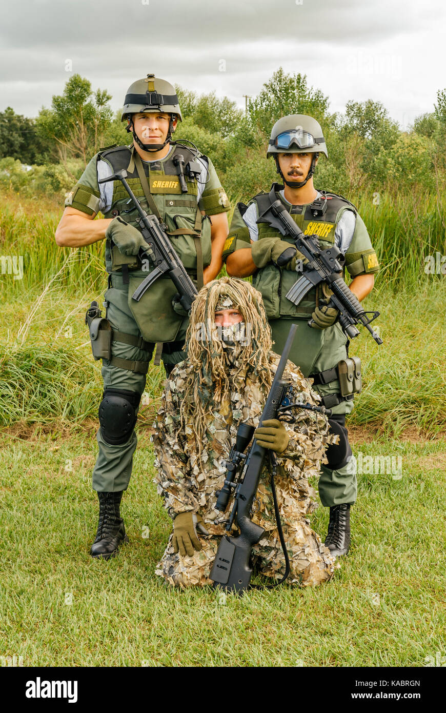 Three members of the Hillsborough County Sheriff's Office SWAT team, with full gear and one in a ghillie suit ready for a day of police training. USA. Stock Photo