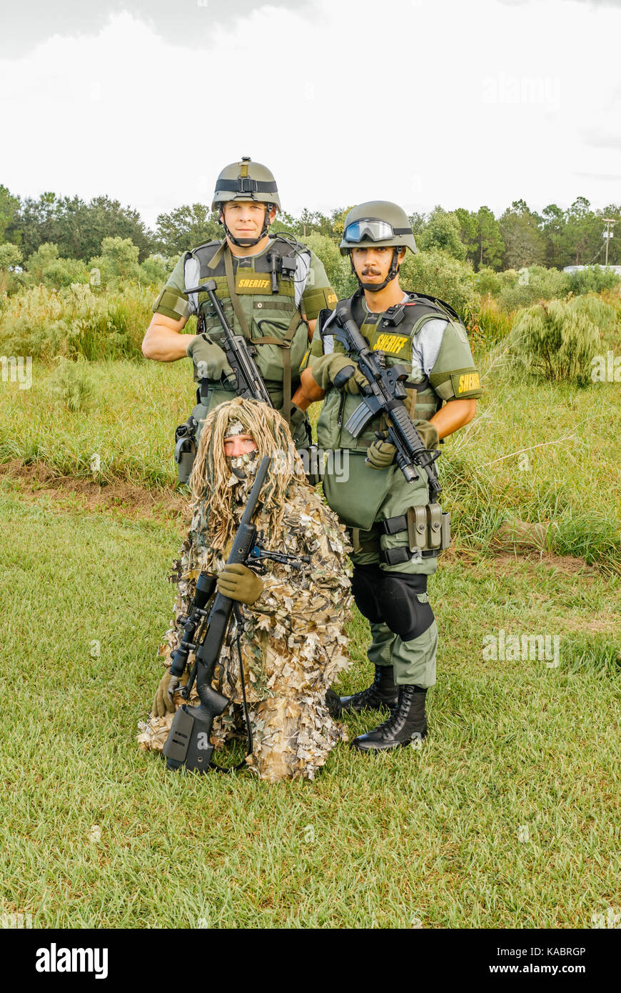Three members of the Hillsborough County Sheriff's Office SWAT team, with full gear and one in a ghillie suit ready for a day of police training. Stock Photo
