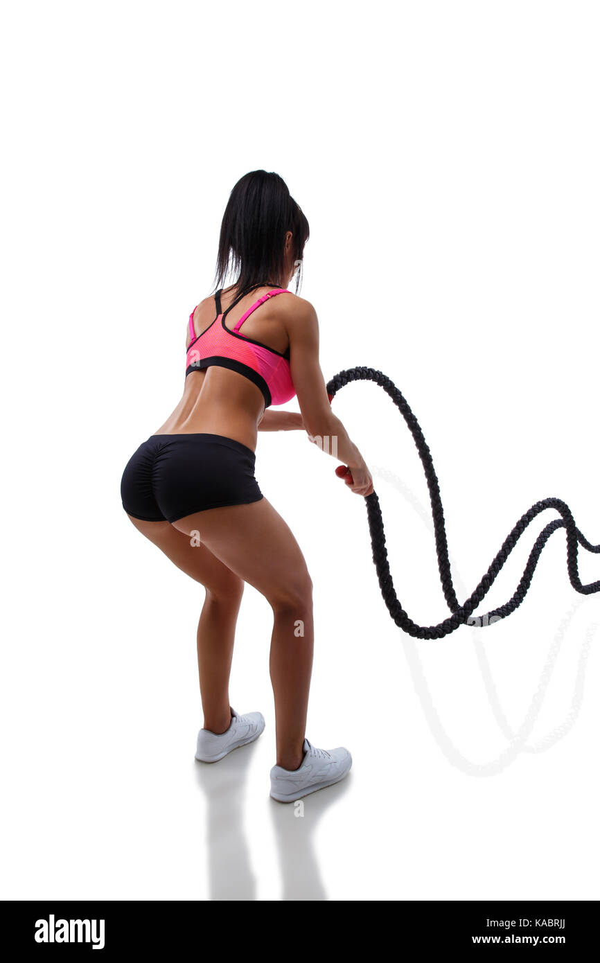 Athletic young woman doing crossfit exercise with rope isolated on white background Stock Photo