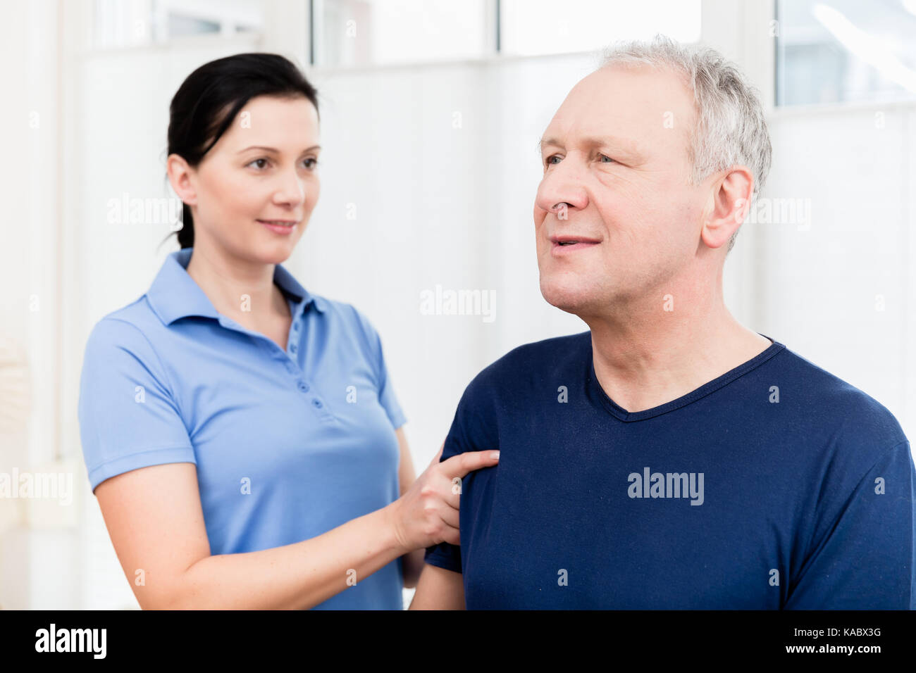 Physio giving shoulder massage to patient Stock Photo