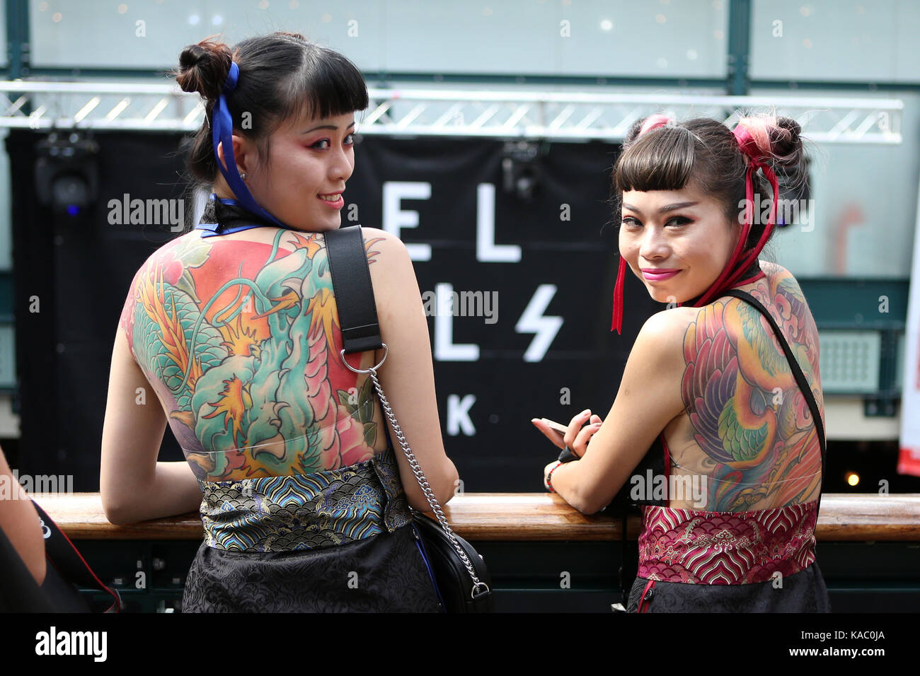 Tattooed back of two women at The International London Tattoo Convention 2017, Tobacco Dock, London, UK. Stock Photo