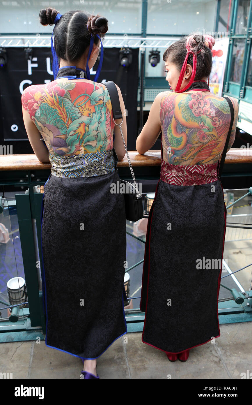 Tattooed back of two women at The International London Tattoo Convention 2017, Tobacco Dock, London, UK. Stock Photo