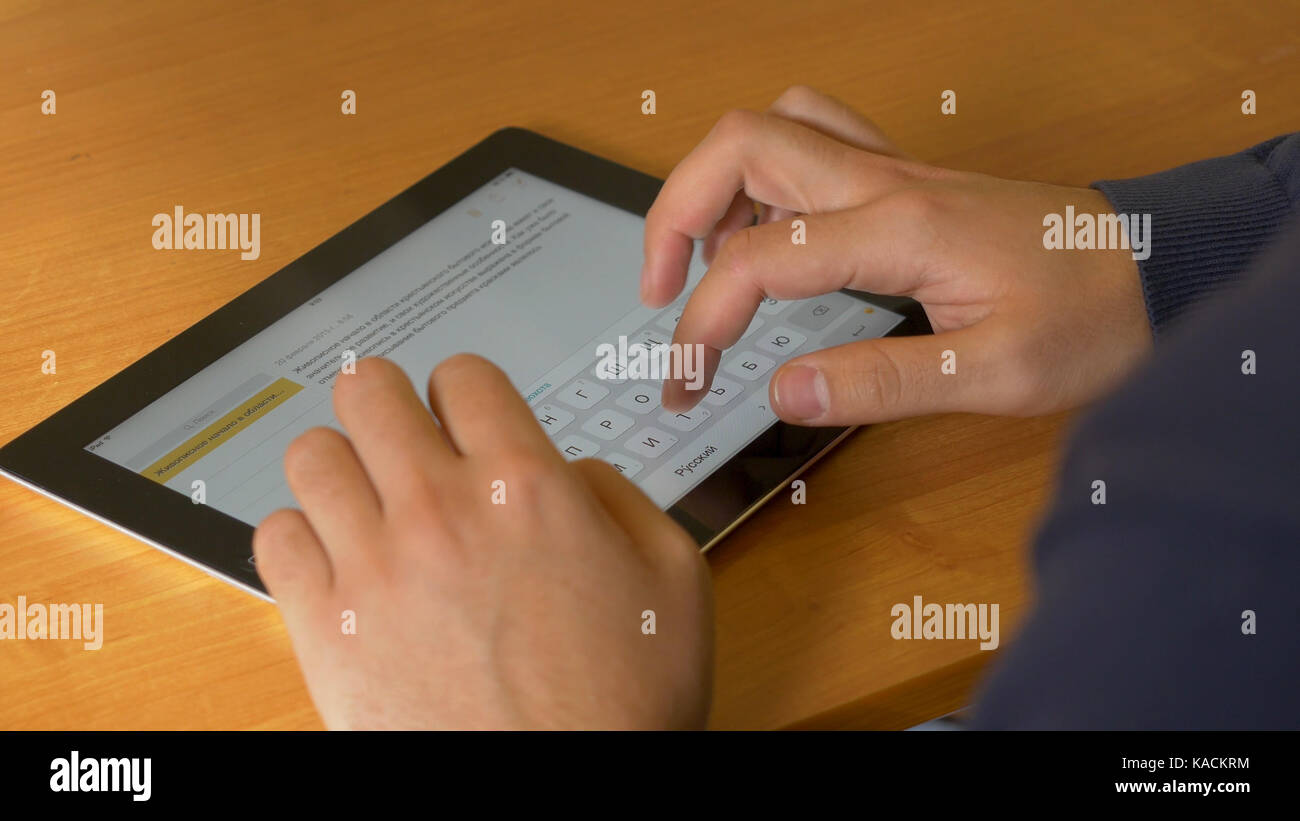 Close-up of male hands using modern digital tablet and computer at ...
