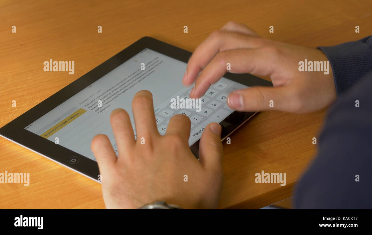 Close-up of male hands using modern digital tablet and computer at ...