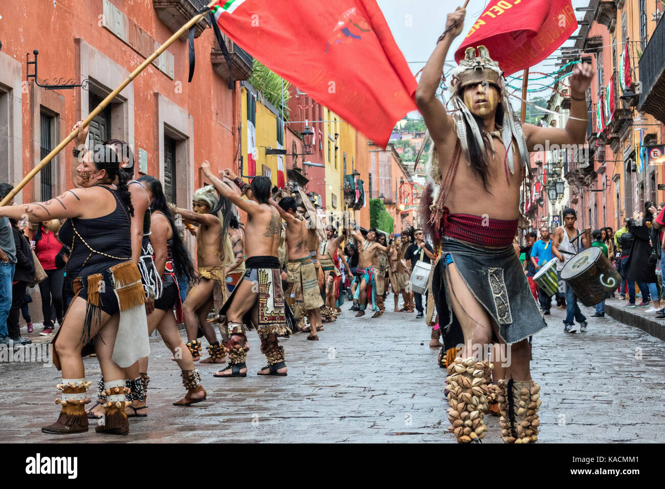 Aztec indians dance in a procession through the historic city during the week long fiesta of the patron saint Saint Michael September 24, 2017 in San Miguel de Allende, Mexico. Stock Photo