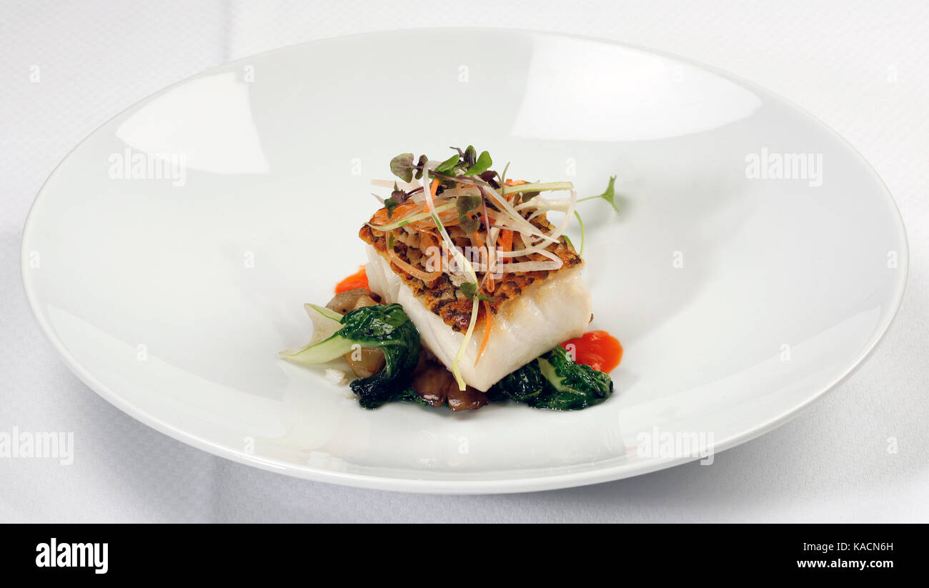 Grilled Sea Bass dinner, with vegetables on white plate. Stock Photo