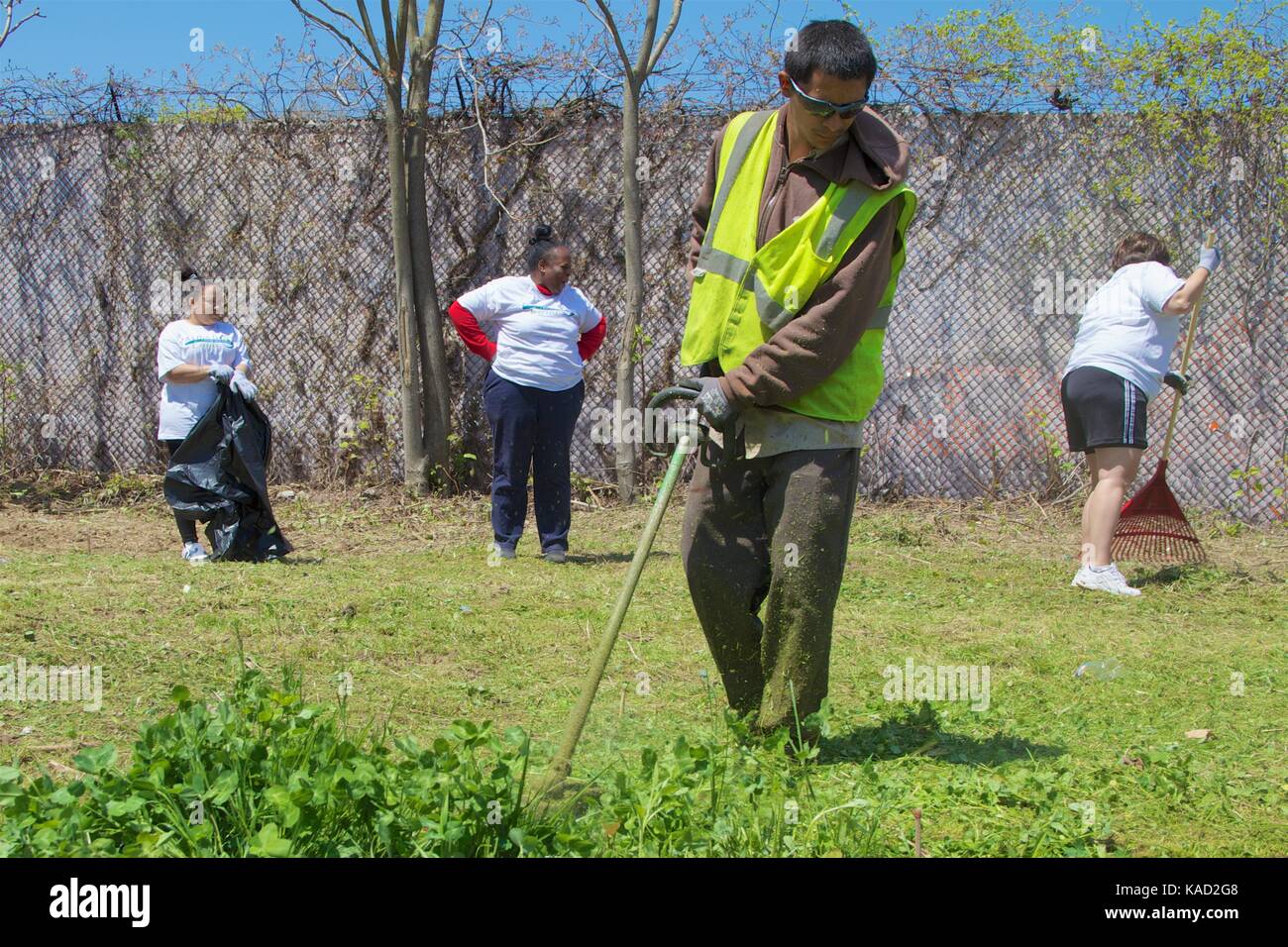 April 26, 2013 - Philadelphia, PA, USA: Volunteers clear weeds, trash and debris from a vacant lot in Philadelphia, Pennsylvania. Stock Photo