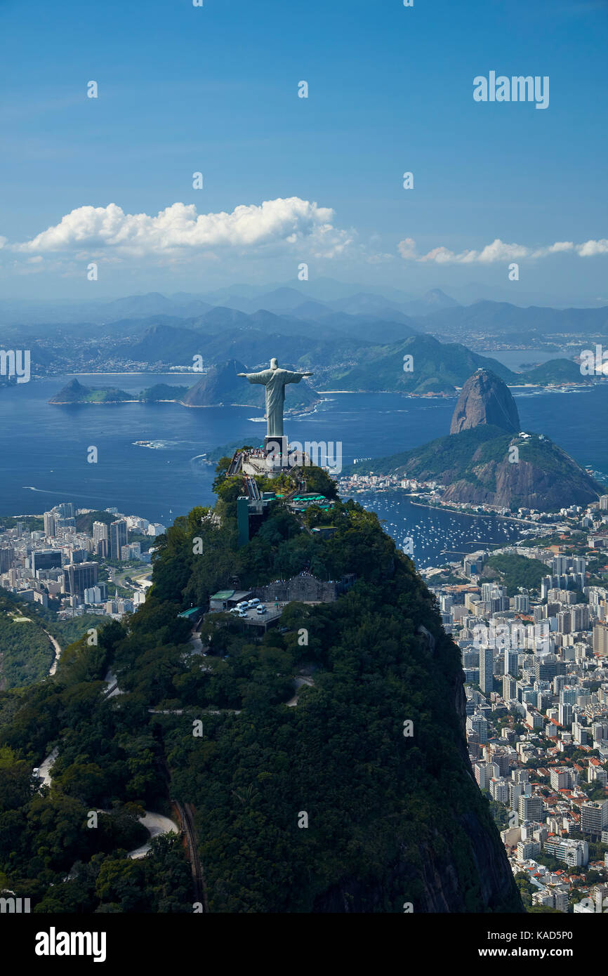 Christ the Redeemer statue atop Corcovado, and Sugarloaf Mountain, Rio de Janeiro, Brazil, South America - aerial Stock Photo