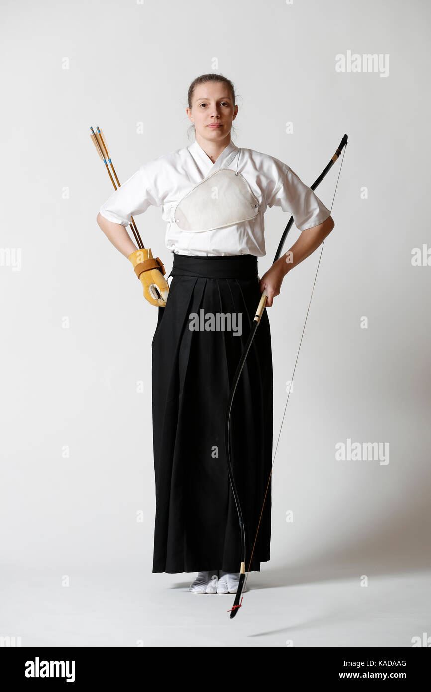 Caucasian woman practicing traditional Kyudo Japanese archery on white background Stock Photo