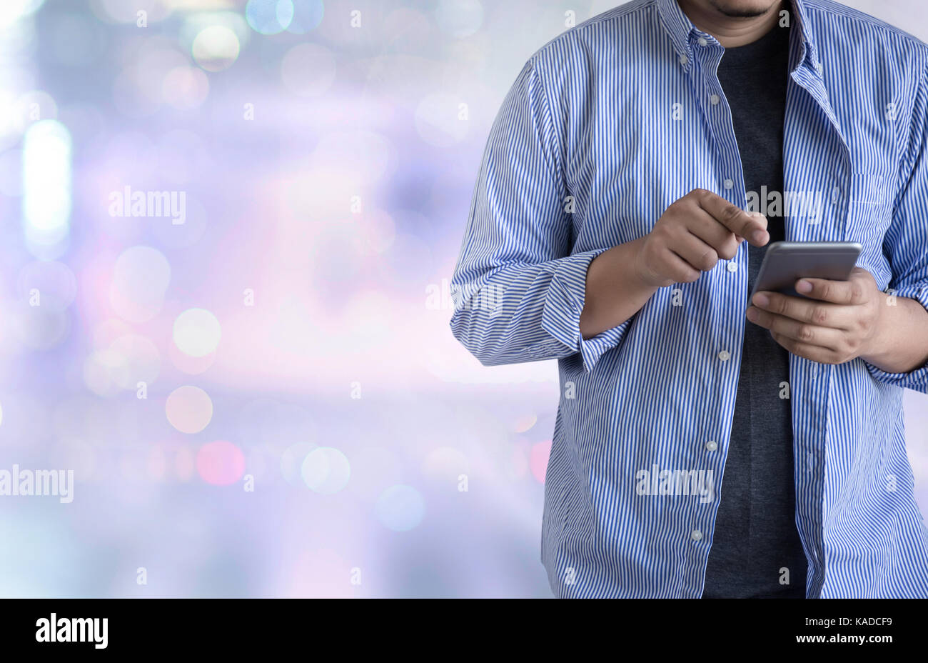 person holding a smartphone on blurred cityscape background Stock Photo