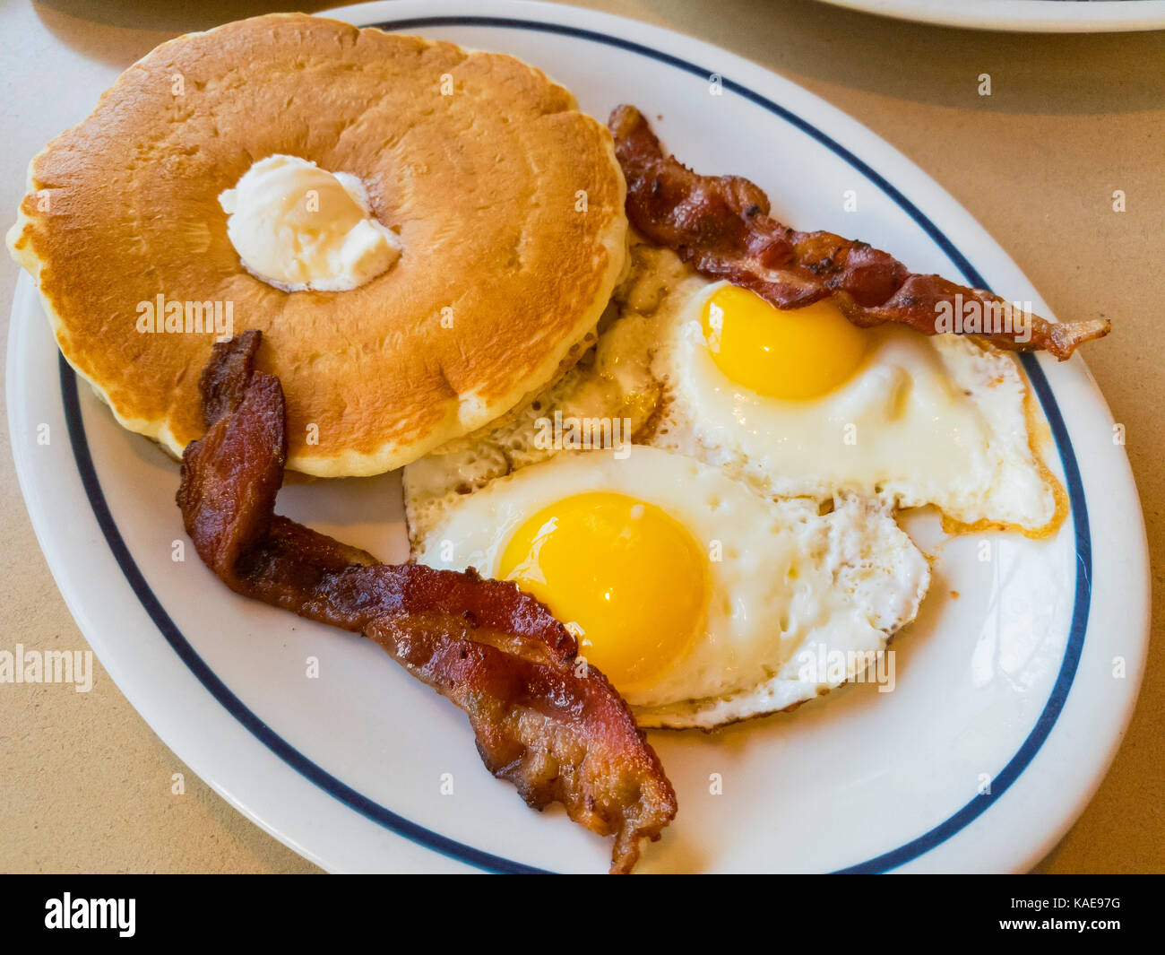 Close up shoot of traidional american breakfast of pancake with eggs and bacon, photo taken at a chain restaurant, Los Angeles, California, United Sta Stock Photo
