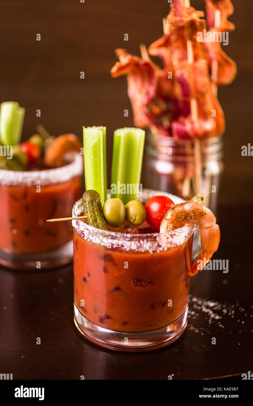 Bloody mary cocktail garnished with celery sticks and olives Stock