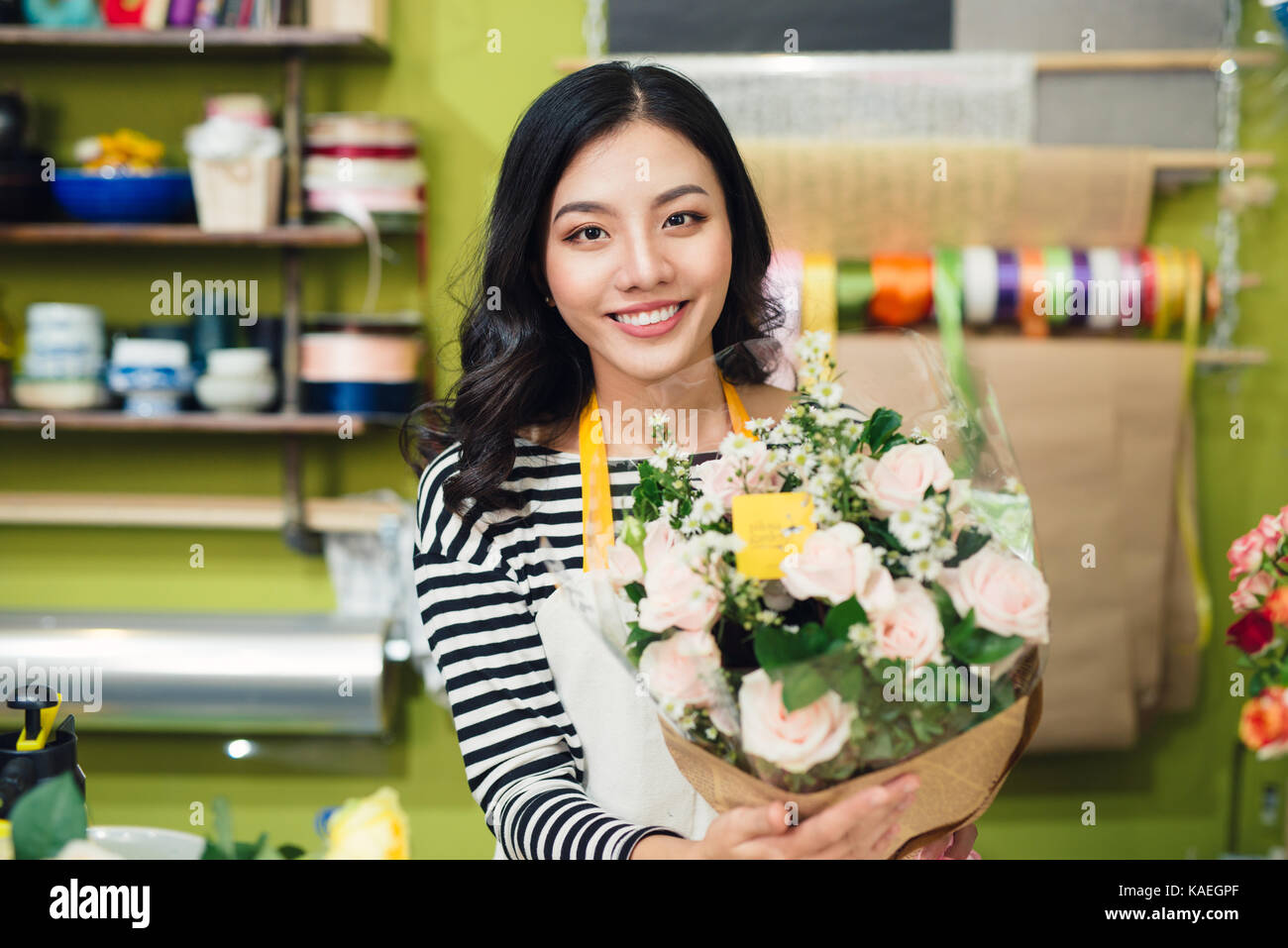 Beautiful asian female florist holding bouquet of flowers Stock Photo ...