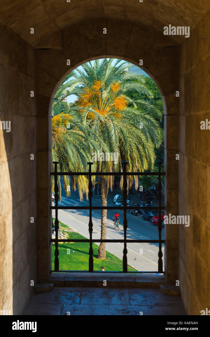 Valencia Spain street, view through an arch window in the Torres Serranos city gate in Valencia showing a cyclist on the Carrer del Comte de Trenor. Stock Photo