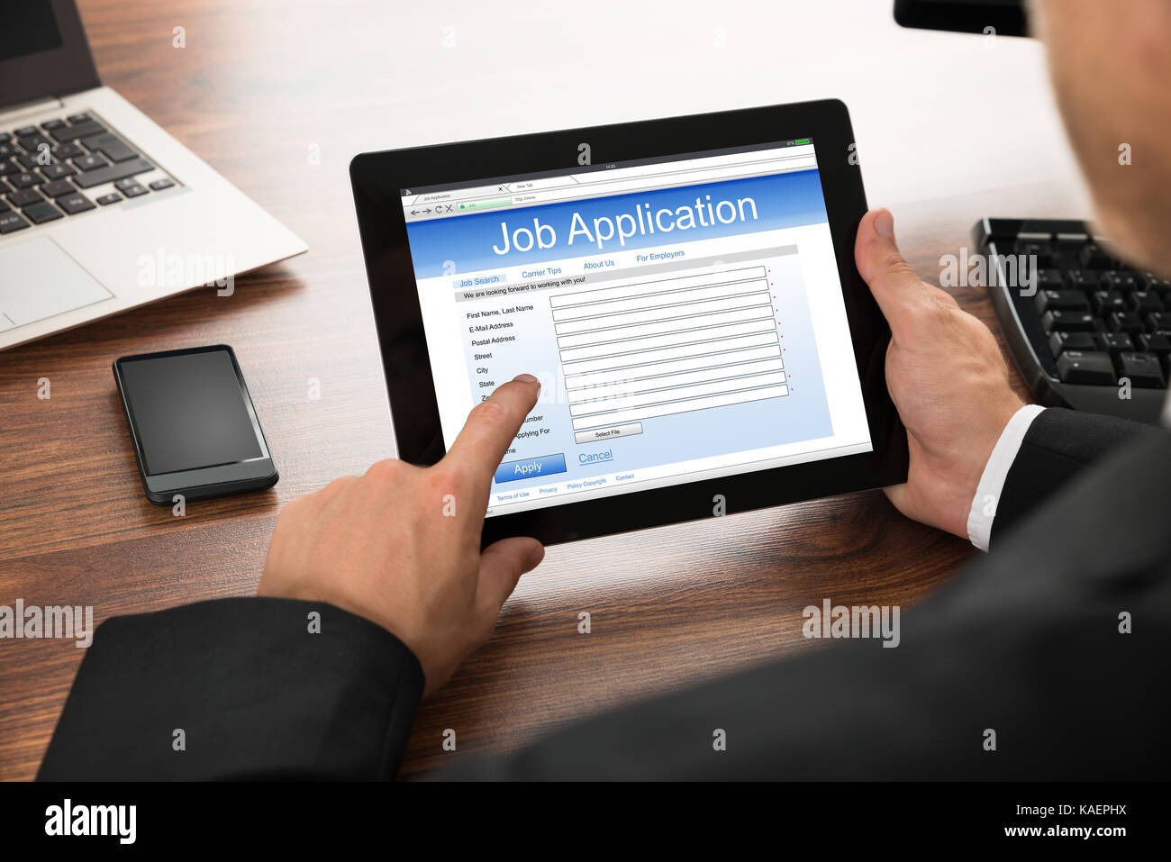 Close-up Of Businessman Filling Online Job Application On Digital Tablet Stock Photo
