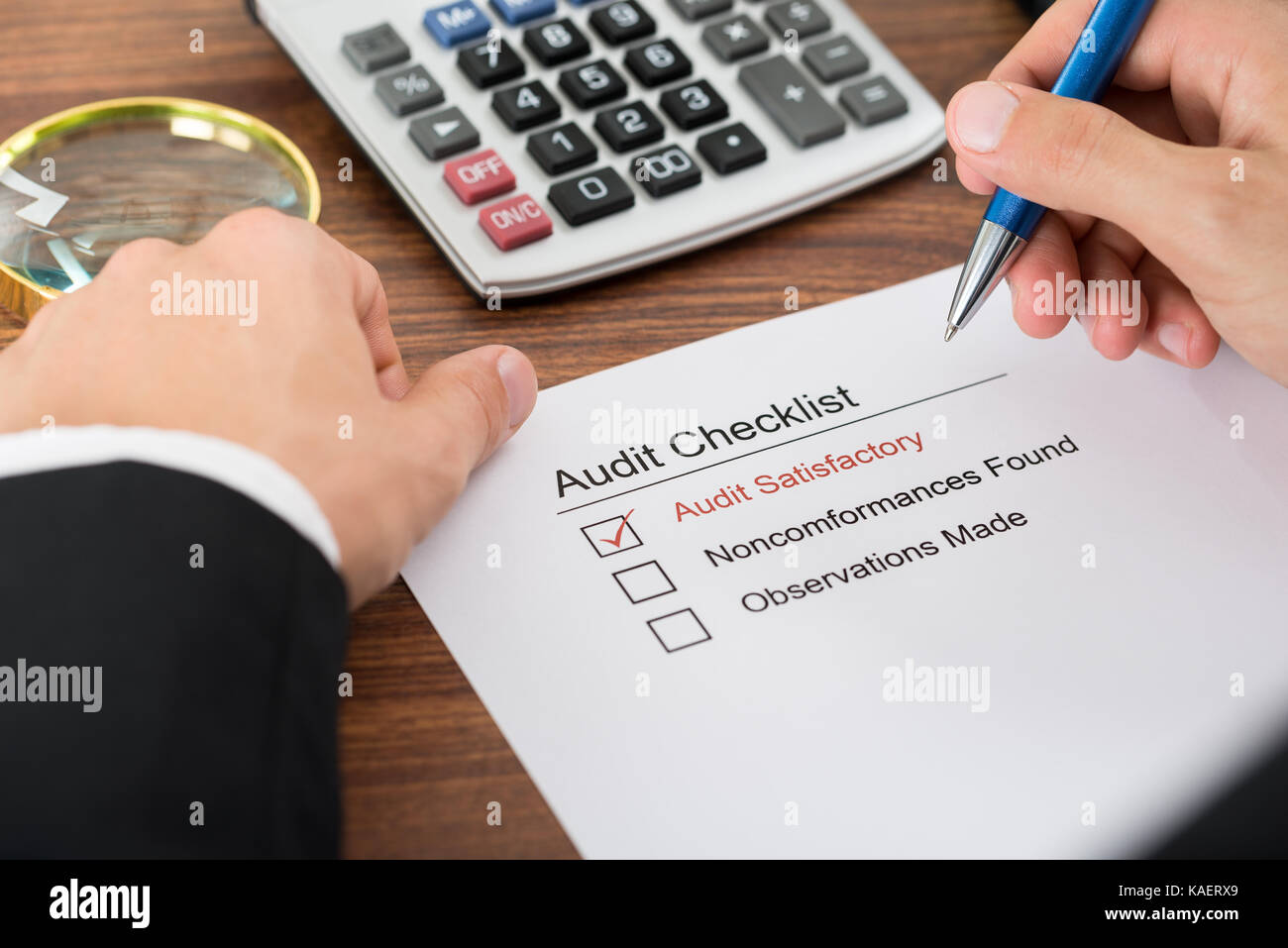 Close Up Of A Person S Hand Filling Audit Checklist Form Stock